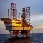 Oil rig at sunset with Jackson Walker logo